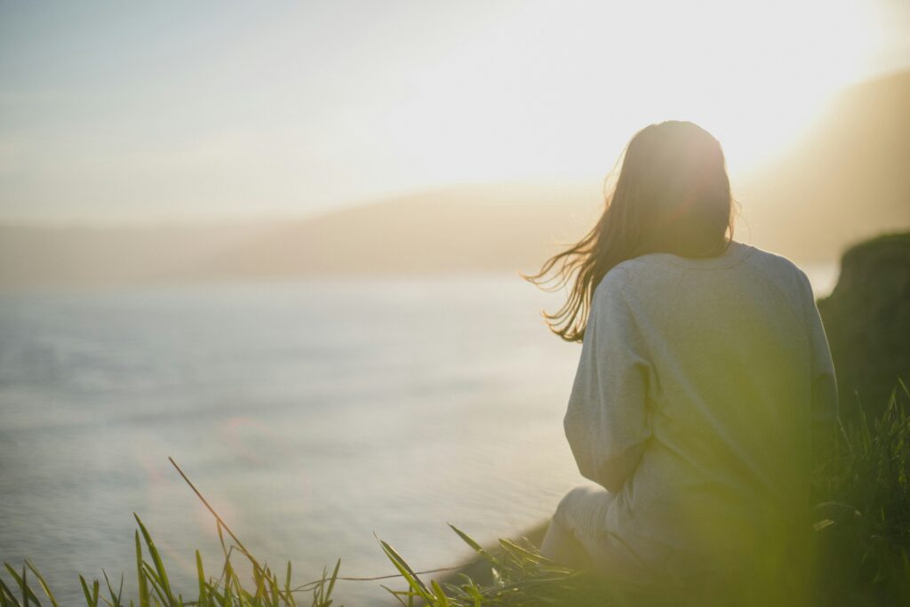 women sitting looking at the ocean signifying nervous system regulation